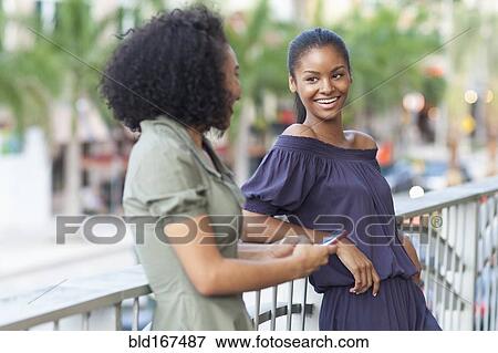 Black women talking on balcony View Large Photo Image Stock Photo - Black women talking on balcony. Fotosearch