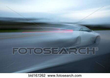 Blurred view of car driving on road View Large Photo Image Stock Image - Blurred view of car driving on road. Fotosearch