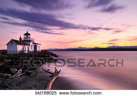 Stock Photography - Blurred view of ocean waves on lighthouse beach at sunset. Fotosearch