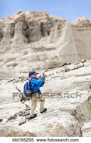 Boy photographing desert rock formations View Large Photo Image Stock Photography - Boy photographing desert rock formations. Fotosearch