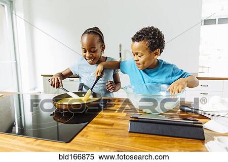 Brother and sister cooking breakfast in kitchen View Large Photo Image Stock Photography - Brother and sister cooking breakfast in kitchen. Fotosearch