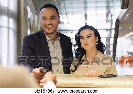 Business people checking into hotel with concierge View Large Photo Image Stock Photo - Business people checking into hotel with concierge. Fotosearch
