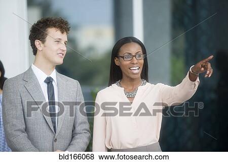 Stock Photo - Business people gesturing in office lobby. Fotosearch