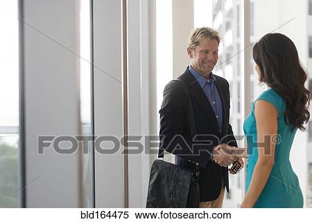 Stock Photography - Business people shaking hands in office. Fotosearch