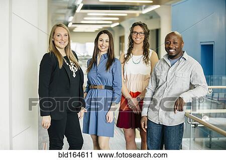 Stock Image - Business people smiling in office. Fotosearch