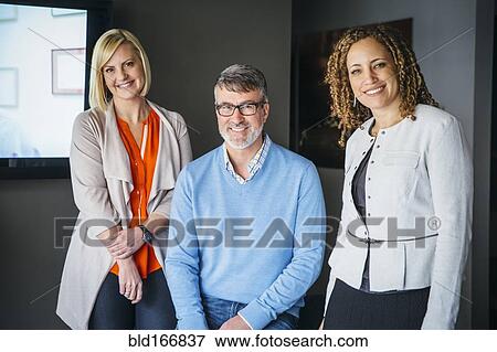 Stock Photo - Business people smiling in office. Fotosearch