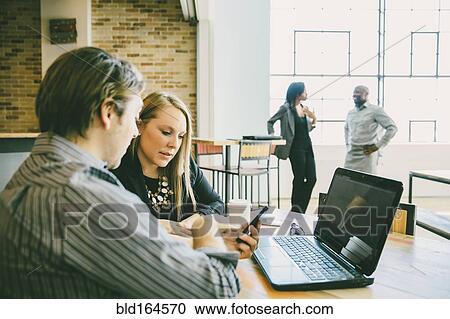 Stock Image - Business people talking in cafe. Fotosearch