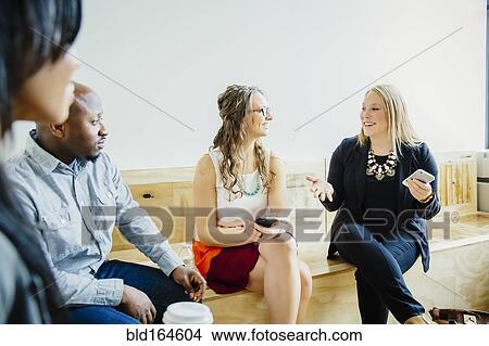 Business people talking in office lobby View Large Photo Image Picture - Business people talking in office lobby. Fotosearch