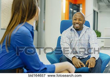 Business people talking in office lobby View Large Photo Image Stock Photo - Business people talking in office lobby. Fotosearch