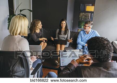 Stock Image - Business people talking in office meeting. Fotosearch