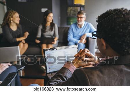 Stock Image - Business people talking in office meeting. Fotosearch