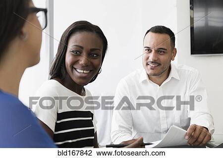 Stock Image - Business people talking in office meeting. Fotosearch