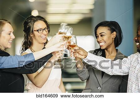 Business people toasting with wine in office View Large Photo Image Stock Photo - Business people toasting with wine in office. Fotosearch