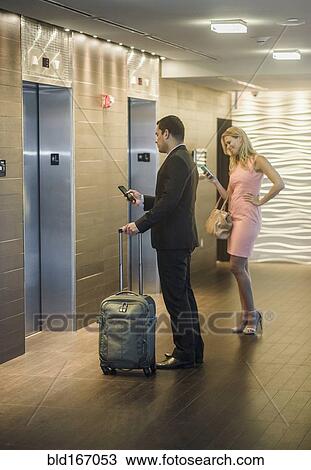 Business people using cell phones and waiting for elevator View Large Photo Image Stock Image - Business people using cell phones and waiting for elevator. Fotosearch