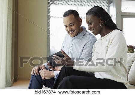 Picture - Business people using digital tablet in hotel lobby. Fotosearch