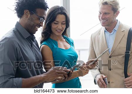 Stock Image - Business people using digital tablet in office. Fotosearch
