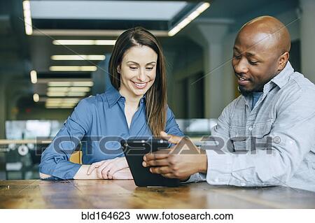 Business people using digital tablet in office View Large Photo Image Stock Image - Business people using digital tablet in office. Fotosearch