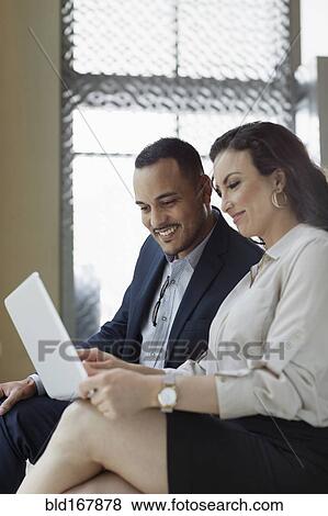Business people using laptop in hotel lobby View Large Photo Image Stock Photo - Business people using laptop in hotel lobby. Fotosearch