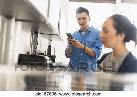 Stock Photograph - Business people using technology in office. Fotosearch