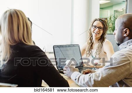 Stock Image - Business people working together in cafe. Fotosearch