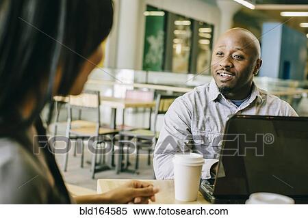 Stock Photography - Business people working together in cafe. Fotosearch