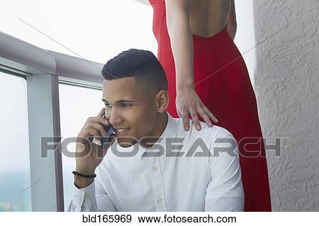 Businessman talking on cell phone near girlfriend View Large Photo Image Stock Photo - Businessman talking on cell phone near girlfriend. Fotosearch