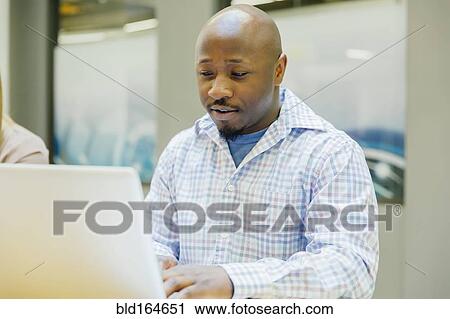 Businessman working on laptop in office View Large Photo Image Stock Image - Businessman working on laptop in office . Fotosearch