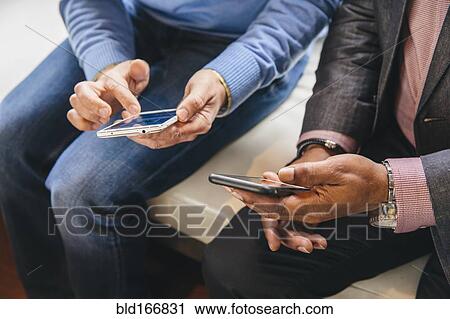 Stock Image - Businessmen using cell phones. Fotosearch