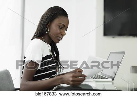 Businesswoman reading notes at office desk View Large Photo Image Stock Image - Businesswoman reading notes at office desk. Fotosearch
