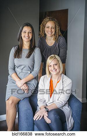 Businesswomen smiling in office View Large Photo Image Stock Photo - Businesswomen smiling in office. Fotosearch