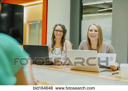 Businesswomen talking in office meeting View Large Photo Image Stock Photo - Businesswomen talking in office meeting. Fotosearch