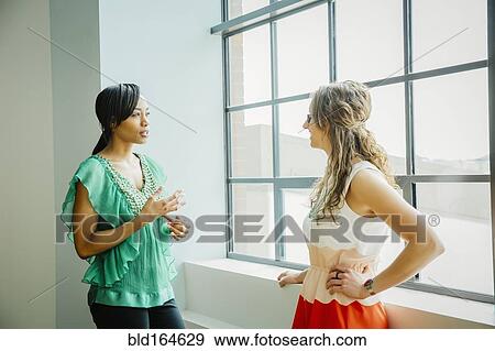 Businesswomen talking in office View Large Photo Image Stock Photo - Businesswomen talking in office. Fotosearch