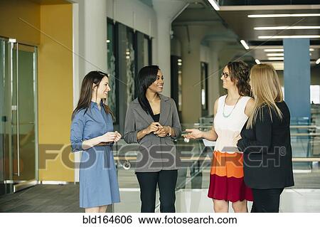Stock Photograph - Businesswomen talking in office. Fotosearch