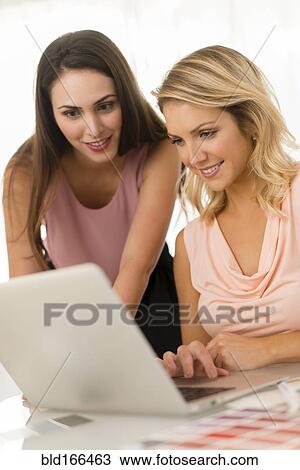 Businesswomen using laptop on table View Large Photo Image Stock Image - Businesswomen using laptop on table. Fotosearch