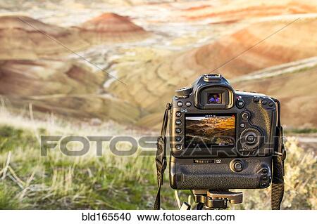 Stock Image - Camera photographing desert landscape, Painted Hills, Oregon, United States. Fotosearch