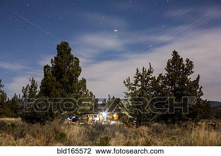 Stock Image - Campsite in remote field under cloudy sky. Fotosearch