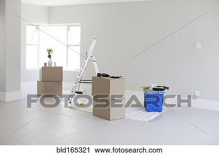 Stock Image - Cardboard boxes and ladder in new home. Fotosearch