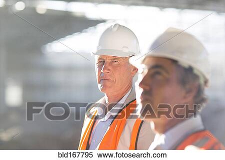 Stock Photography - Caucasian architects standing at construction site. Fotosearch