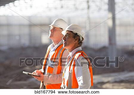 Picture - Caucasian architects using digital tablet at construction site. Fotosearch