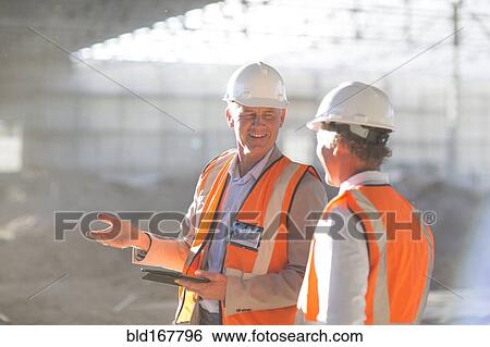 Caucasian architects using digital tablet at construction site View Large Photo Image Stock Photograph - Caucasian architects using digital tablet at construction site. Fotosearch