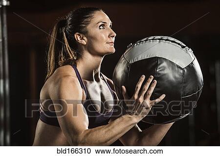 Caucasian athlete lifting resistance ball in gym View Large Photo Image Stock Image - Caucasian athlete lifting resistance ball in gym. Fotosearch