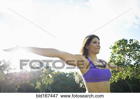 Stock Photo - Caucasian athlete practicing yoga in park. Fotosearch