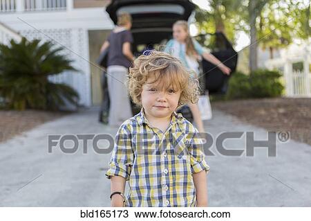 Stock Image - Caucasian baby boy standing in driveway. Fotosearch