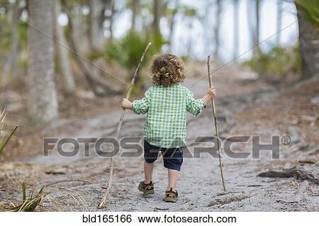 Stock Photograph - Caucasian baby boy walking on dirt path. Fotosearch