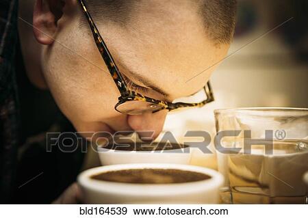 Caucasian barista smelling coffee in cup View Large Photo Image Stock Photo - Caucasian barista smelling coffee in cup. Fotosearch