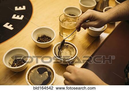 Stock Image - Caucasian barista tasting coffee in coffee shop. Fotosearch