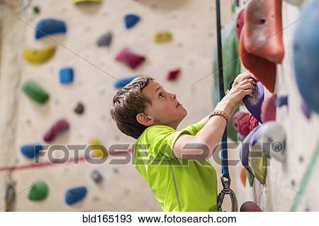 Caucasian boy climbing rock wall indoors View Large Photo Image Stock Image - Caucasian boy climbing rock wall indoors. Fotosearch