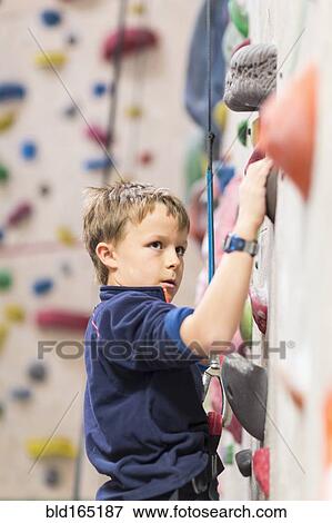 Caucasian boy climbing rock wall indoors View Large Photo Image Stock Photo - Caucasian boy climbing rock wall indoors. Fotosearch