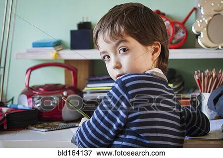 Caucasian boy giving doing homework at desk View Large Photo Image Stock Photo - Caucasian boy giving doing homework at desk. Fotosearch