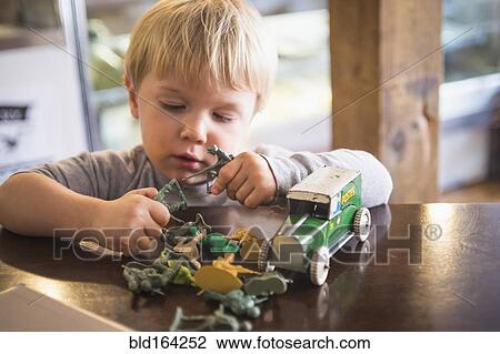Caucasian boy playing with toys on table View Large Photo Image Stock Image - Caucasian boy playing with toys on table. Fotosearch